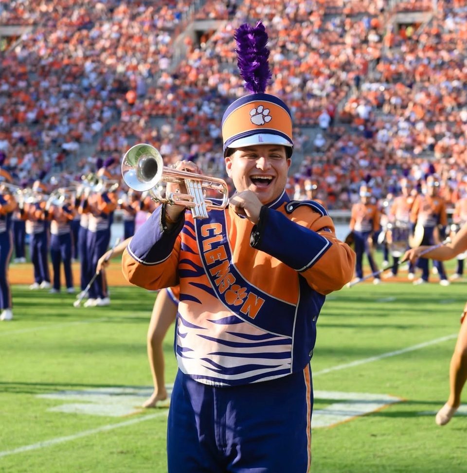 Clemson marching band member playing trumpet on the field